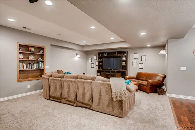 a living room with furniture a flat screen tv and a window