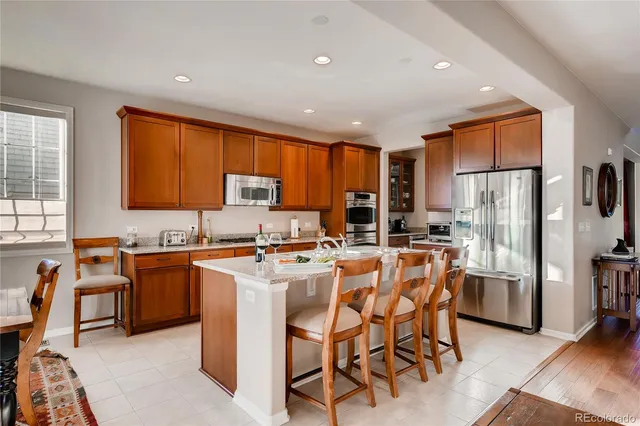 a kitchen with stainless steel appliances granite countertop refrigerator stove microwave and sink