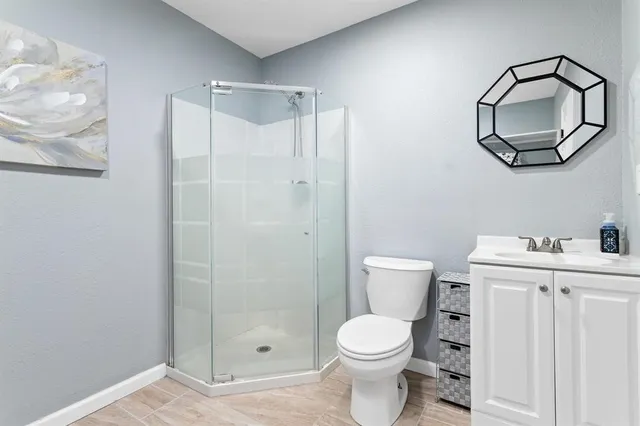 a bathroom with a toilet a sink and shower