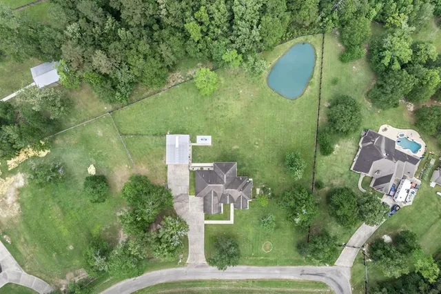 an aerial view of a house with swimming pool and green space
