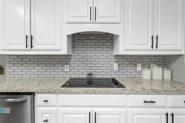 a kitchen with granite countertop white cabinets and appliances