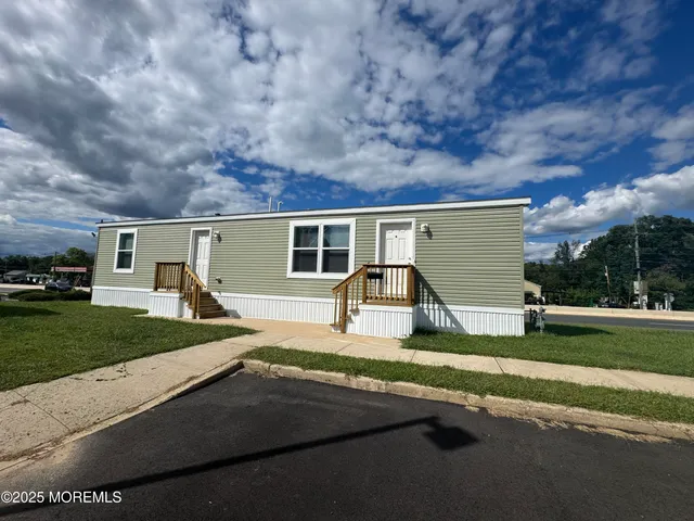 a view of a house with a big yard and a large parking space