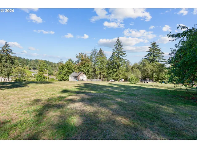 a view of a fountain in front of a house with a yard