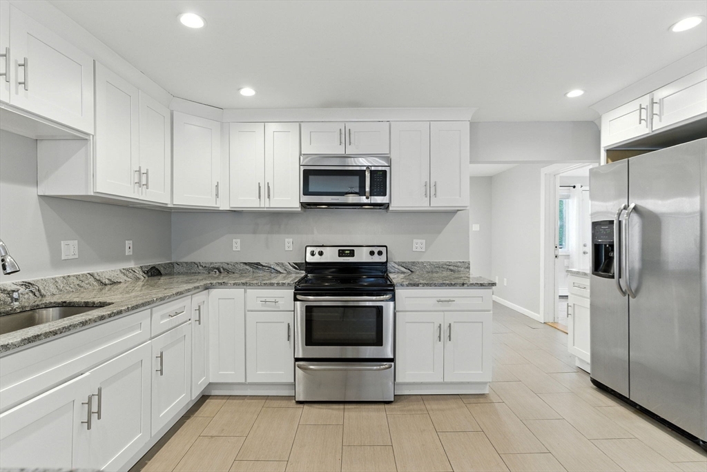 18 Holly Road Holbrook, MA 02343 - Photo 4 of 28 a kitchen with granite countertop white cabinets and stainless steel appliances