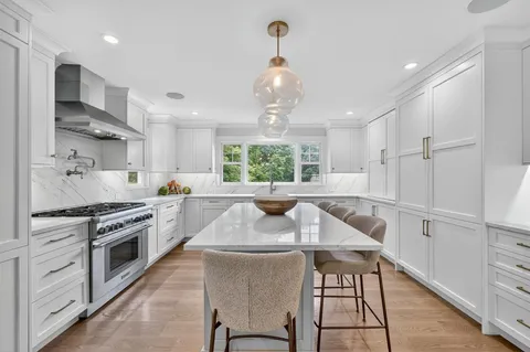 a kitchen with stainless steel appliances kitchen island granite countertop a stove a sink and a refrigerator