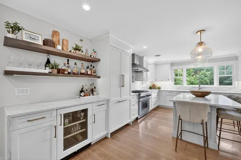 a kitchen with white cabinets and window