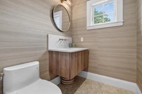 a bathroom with a sink a toilet and a mirror