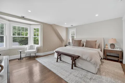a bedroom with a bed and large window