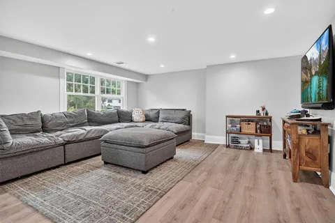 a living room with furniture a large window and a flat screen tv