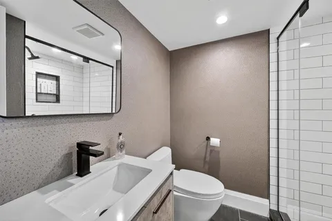 a bathroom with a toilet sink and mirror