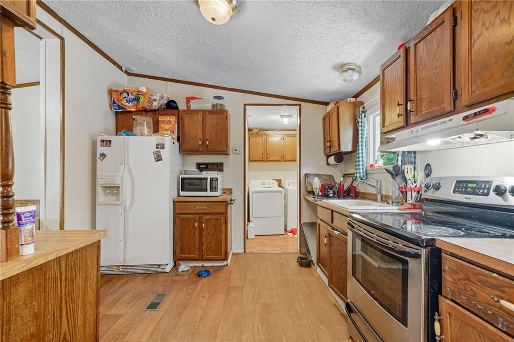 2450 Jones Mountain Road Talking Rock, GA 30175 - Photo 18 of 40 a kitchen with stainless steel appliances granite countertop a refrigerator and a stove top oven