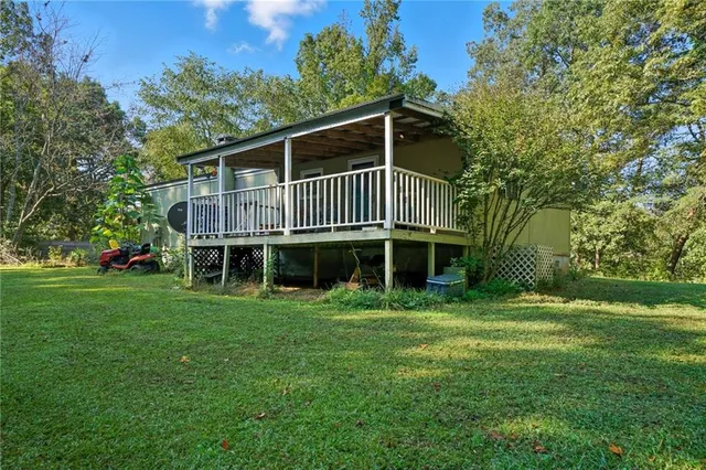 a view of a house with a big yard and large trees