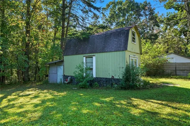 a view of a backyard with potted plants and large tree