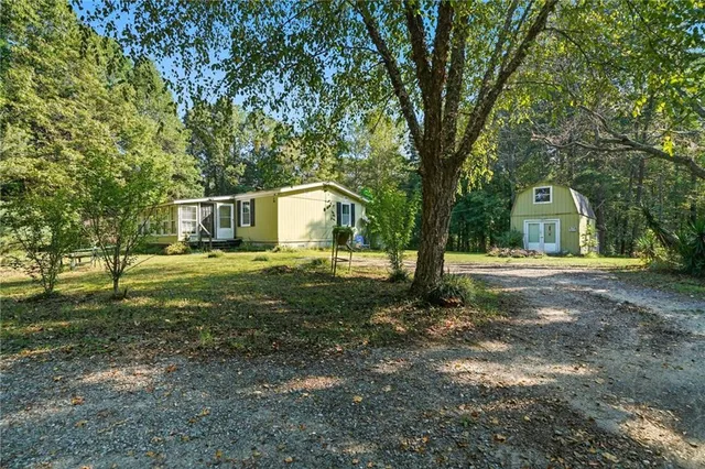 a view of a house with backyard and trees