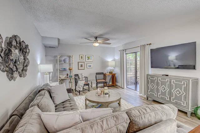 a room with stainless steel appliances kitchen island granite countertop a table chairs refrigerator and microwave