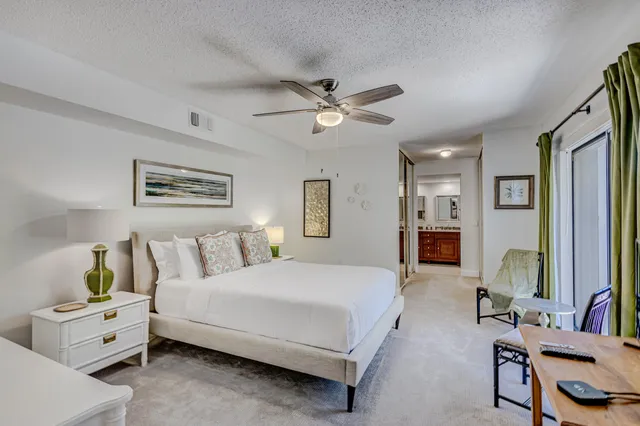 a bedroom with a bed and a flat tv screen on dresser