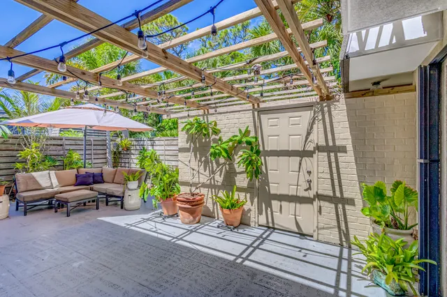 a patio with a table and chairs under an umbrella