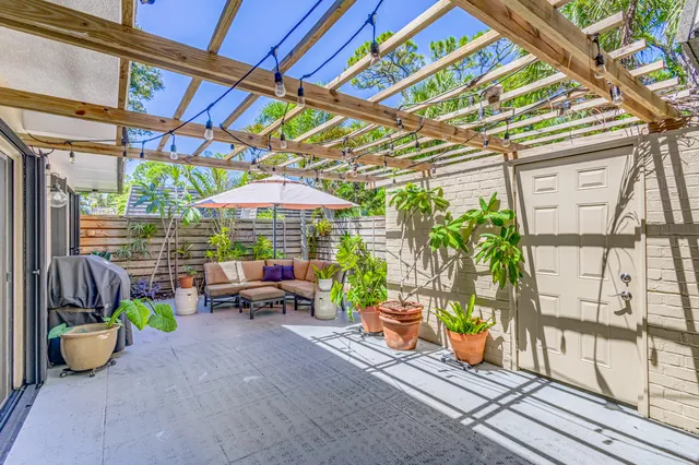 a view of a patio with table and chairs potted plants