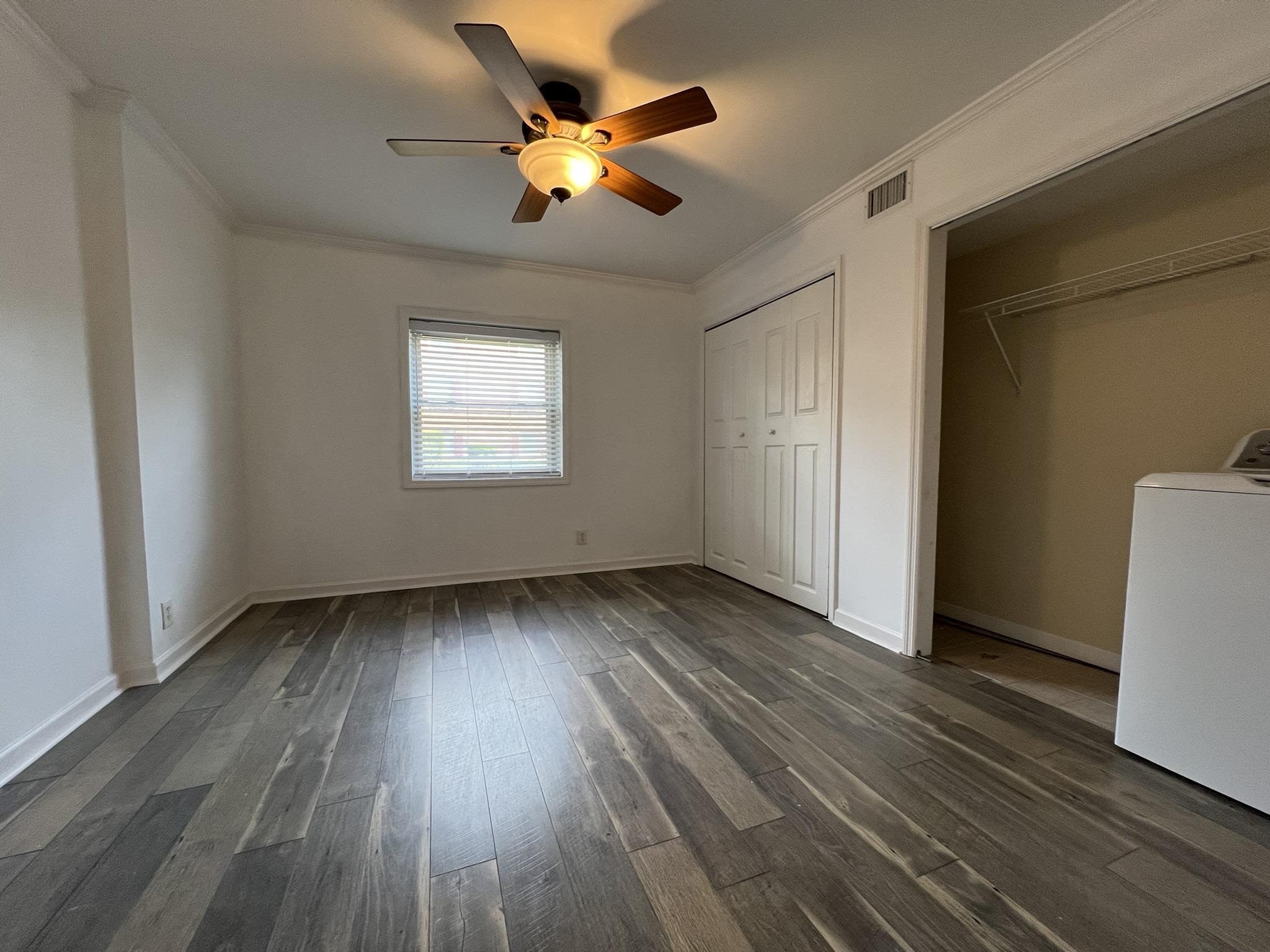 1207 Middle Court, Unit 102 Memphis, TN 38119 - Photo 19 of 31 a view of an empty room with wooden floor and a window