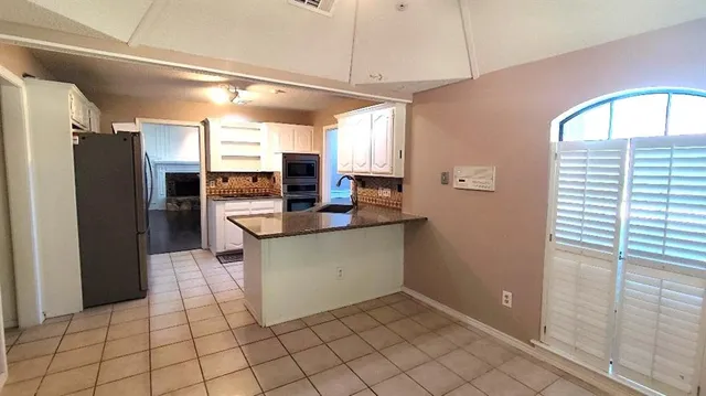 a kitchen with stainless steel appliances granite countertop a refrigerator and a sink