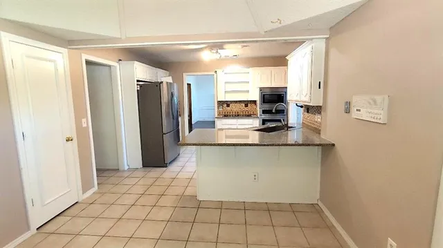 a kitchen with stainless steel appliances a refrigerator and a counter top space