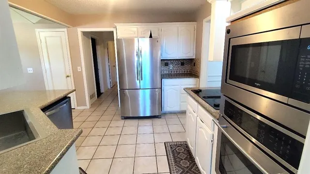 a kitchen with stainless steel appliances a refrigerator and a stove top oven