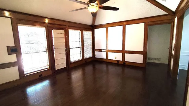 a view of empty room with wooden floor and fan