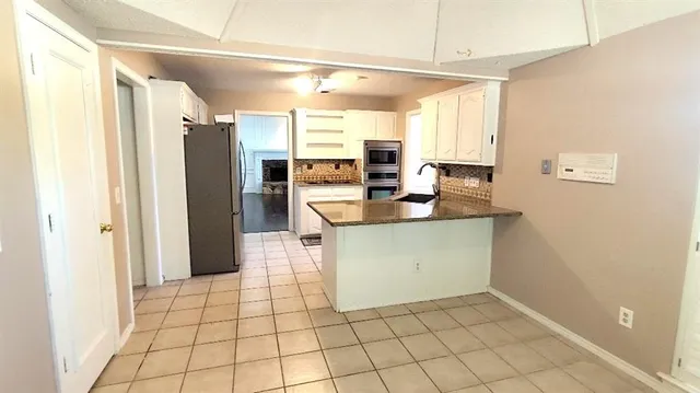 a kitchen with a sink a counter top space and stainless steel appliances