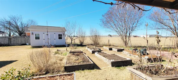 a view of a backyard with table and chairs and wooden fence