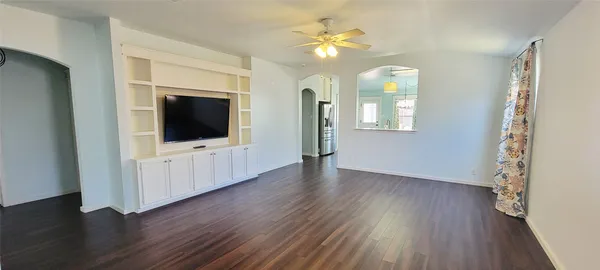 an empty room with wooden floor and mirror