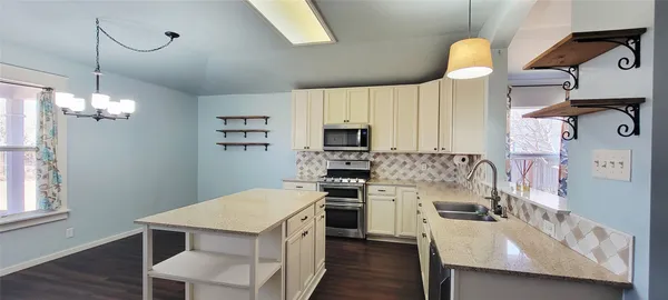 a kitchen that has a lot of cabinets and wooden floor