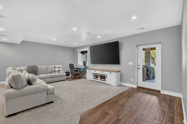 1263 East 1200th South Springville, UT 84663 - Photo 42 of 60 Spacious open-concept room featuring recessed lighting, a built-in media console with a wood top, a wood-finish flooring section, and a glass-paned exterior door