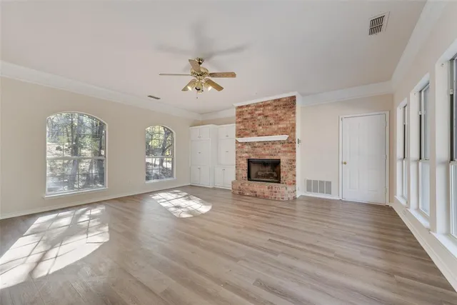 a view of an empty room with a window and fireplace