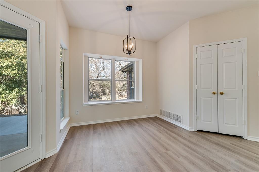 421 Roland Drive Keller, TX 76248 - Photo 13 of 40 an empty room with wooden floor cabinet and windows
