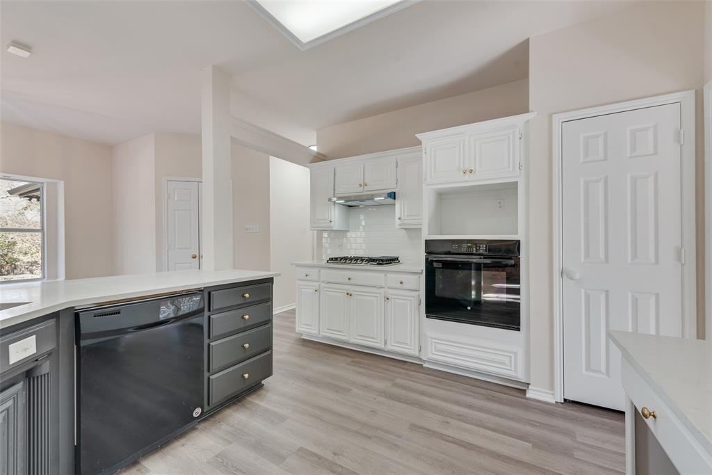 421 Roland Drive Keller, TX 76248 - Photo 15 of 40 a kitchen with granite countertop white cabinets and appliances