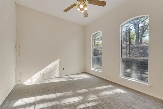 a view of a livingroom with a ceiling fan and window