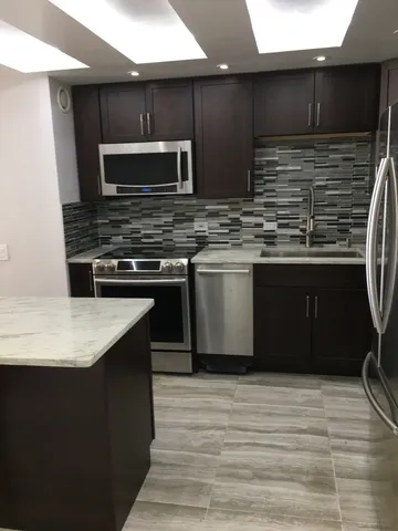 a kitchen with stainless steel appliances wooden cabinets and a sink