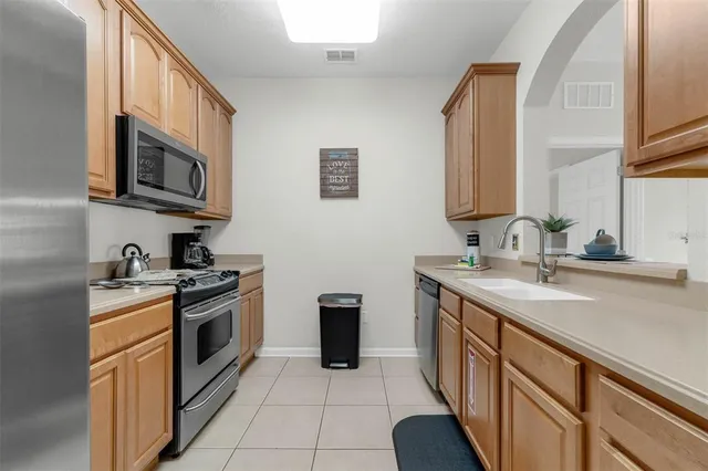 a kitchen with a sink a refrigerator and cabinets