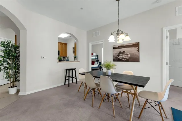 a view of a dining room with furniture and a chandelier