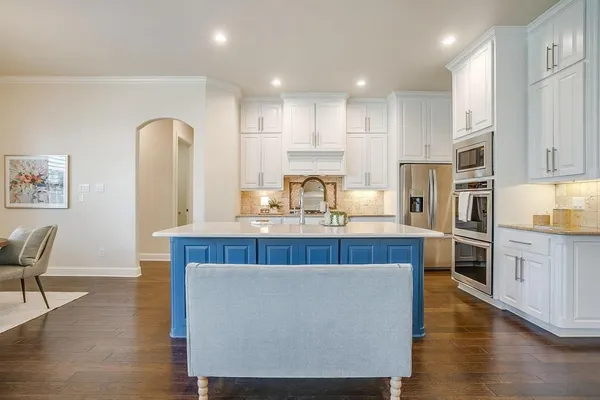 a kitchen with stainless steel appliances granite countertop a table chairs sink refrigerator and cabinets