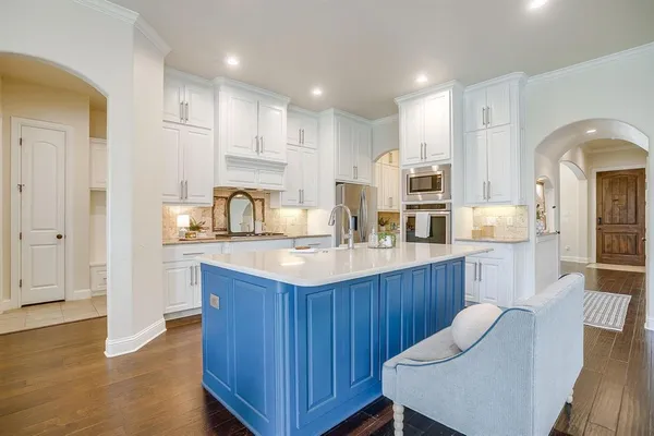 a kitchen with kitchen island granite countertop a sink cabinets and wooden floor