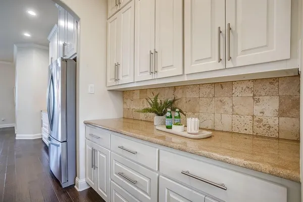 a kitchen with granite countertop stainless steel appliances white cabinets and a sink