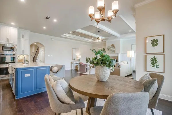 a view of a dining room with furniture a chandelier and wooden floor