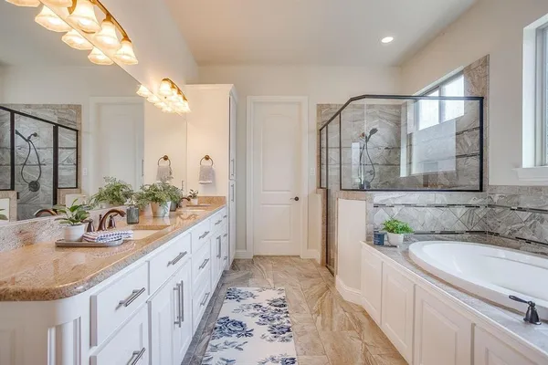 a bathroom with a granite countertop double vanity sink and a mirror