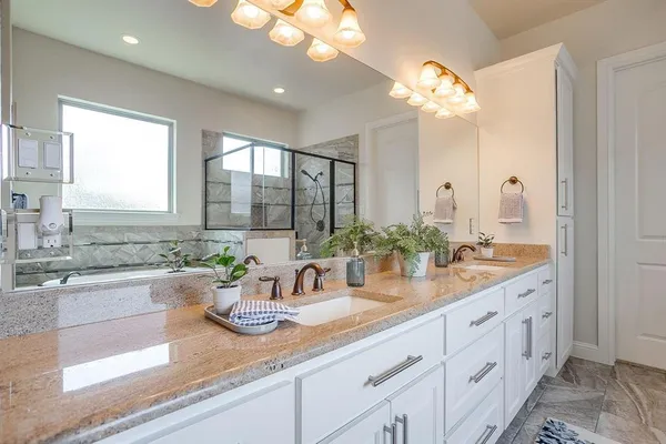 a bathroom with a granite countertop sink a large mirror and a window