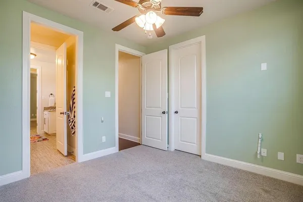 a view of a room with a ceiling fan and bathroom space