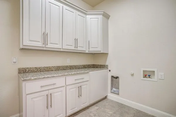 a kitchen with granite countertop white cabinets and a sink