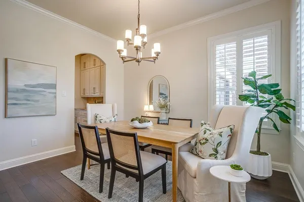 a view of a dining room with furniture a chandelier and wooden floor