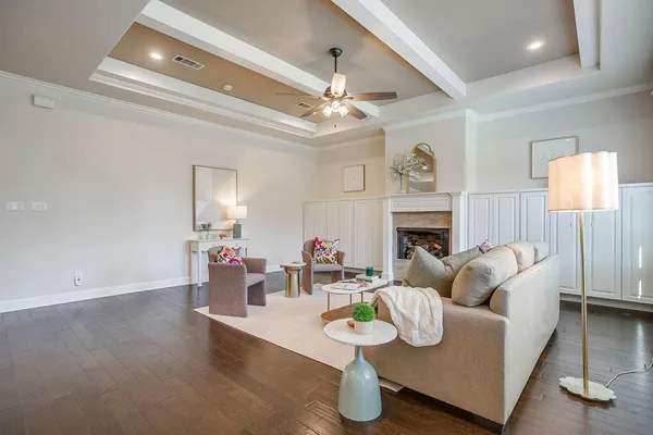 a living room with furniture a fireplace and a chandelier
