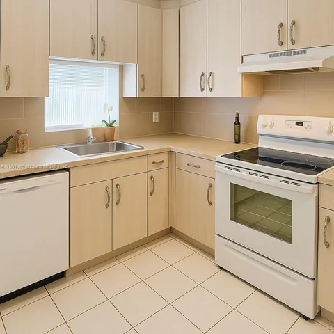 a kitchen with granite countertop white cabinets and white appliances